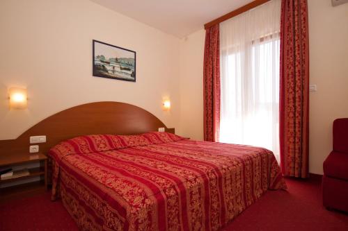 比奥格勒·纳·莫鲁HOTEL MEDUZA的一间卧室设有红色的床和窗户。