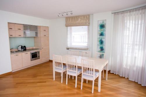 华沙Szucha Residence Apartments by Global Apart的一间厨房,里面配有白色的桌子和椅子