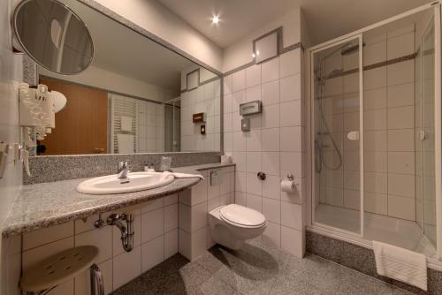 兰施图尔Hotel Merkur的浴室配有卫生间、盥洗盆和淋浴。