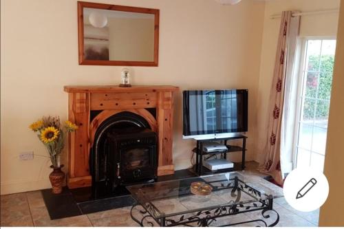 纳文Mullaghbeag Lodge的客厅设有壁炉和电视。