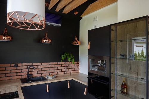什切尔克Apartament Balance z prywatną sauną的厨房设有黑色的墙壁和砖墙