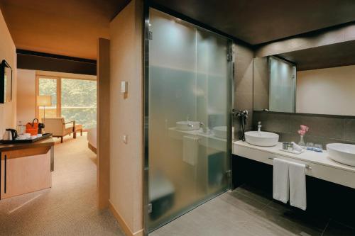 毕尔巴鄂Hesperia Bilbao的一间带两个水槽和玻璃淋浴间的浴室