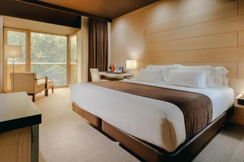 毕尔巴鄂Hesperia Bilbao的酒店客房设有一张大床和一张书桌。
