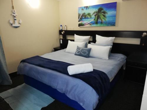 比勒陀利亚格兰查帕拉尔旅馆的一间卧室配有一张带蓝白色枕头的大床