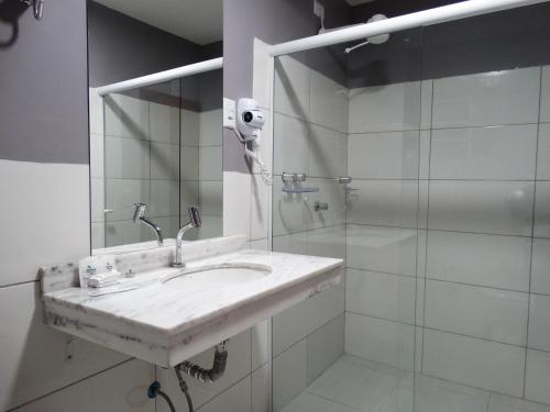 卡塞雷斯Riviera Pantanal Hotel的白色的浴室设有水槽和淋浴。