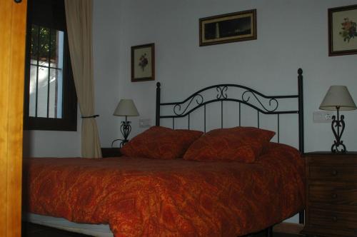 扎霍拉茉莉花度假屋的一间卧室配有一张带橙色毯子的床