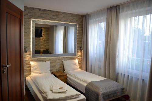 格涅兹诺Villa Vip的酒店客房,设有两张床和镜子