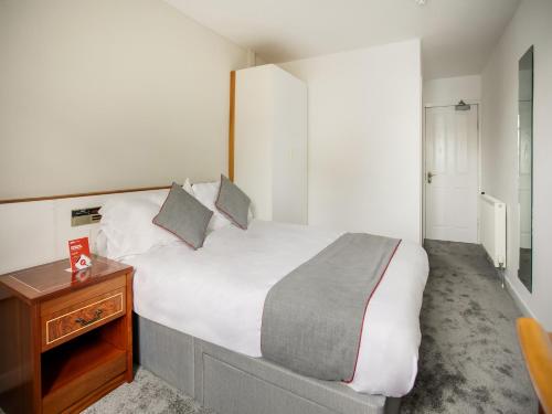 艾尔OYO Glenpark Hotel, Ayr Central的一间卧室配有一张大床和一张木桌