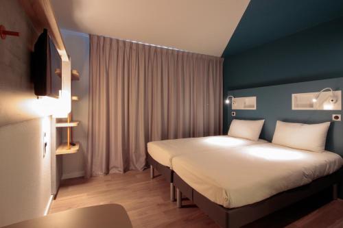 卡奥尔ibis budget Cahors的酒店客房设有两张床和窗户。