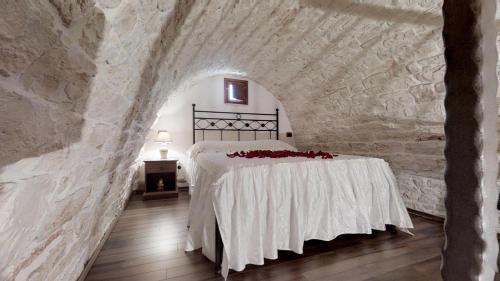 阿尔贝罗贝洛Il Trullo dei Sogni的卧室配有一张石墙床