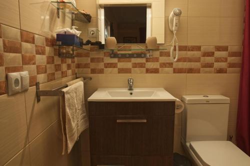 圣巴托洛梅Finca Cortez的一间带水槽和卫生间的浴室以及一部电话