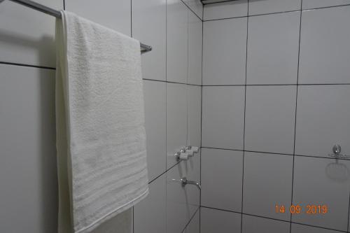 伊瓜苏港Mediterráneo Suites的带淋浴和白色毛巾的浴室