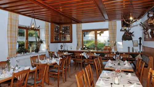 贝尔恩里德Hotel Winterl的餐厅设有木桌、椅子和窗户。