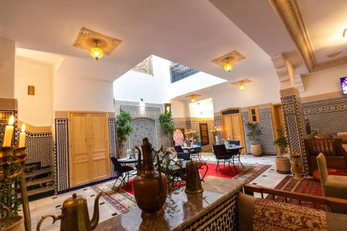 非斯里亚德阿尔玛坎庭院旅馆的大型客厅配有桌椅