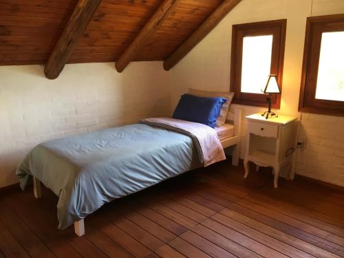 拉帕洛马La Ranita Negra的一间卧室配有床、床头柜和2扇窗户