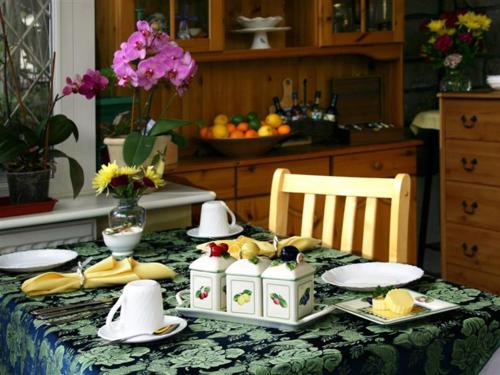 滨海韦斯顿林登旅馆的一张桌子,上面有盘子和水果,上面有桌布