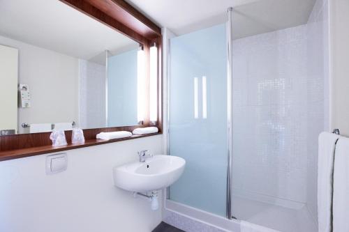 索肖钟楼蒙贝里亚德索肖酒店的白色的浴室设有水槽和淋浴。