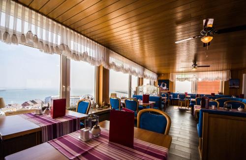 黑尔戈兰岛加尔尼全景酒店的用餐室设有桌椅和窗户。