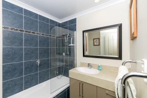 汉密尔顿Daffodil Bed and Breakfast的一间带水槽、浴缸和镜子的浴室