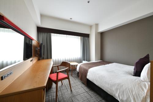 广岛西日本旅客铁道酒店集团的酒店客房设有一张床、一张书桌和一台电视机。