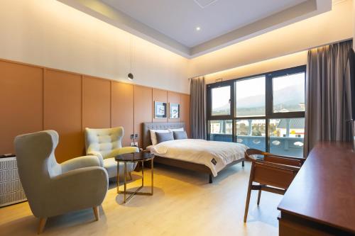 庆州Brown Dot Hotel Gyeongju的配有一张床和一把椅子的酒店客房