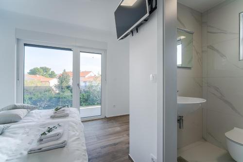 克尔克Villa Čimić的白色的客房设有床和水槽