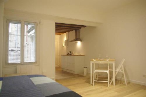 第戎Dijon Standing Historic City Apartment的一间卧室配有一张床、一张桌子和一张桌子
