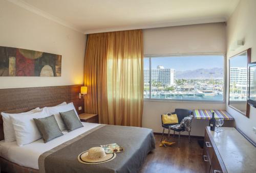 埃拉特凯撒总理埃拉特酒店 的酒店客房设有一张带书桌的床和窗户。