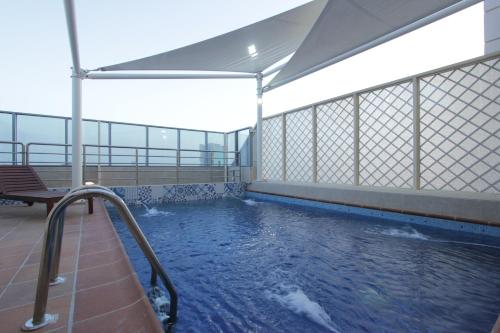 吉达Taj Jeddah Hotel Apartment的一个带长凳和一些水的游泳池
