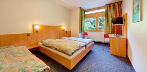 菲施Sport Resort Fiesch, Garni Aletsch的酒店客房,配有床和电视