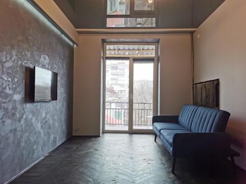 苏梅Loft style apartments in the center的客厅设有蓝色的沙发和窗户。