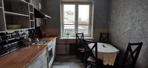 苏梅Loft style apartments in the center的厨房配有桌椅和窗户。