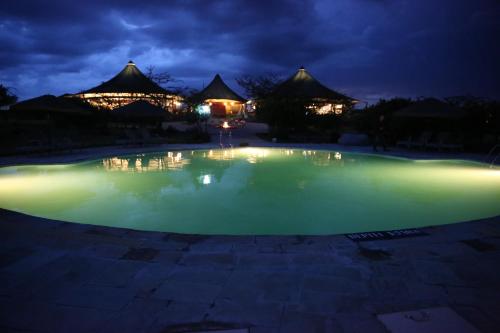 塔勒克马赛马拉AA酒店的夜晚的水池,建筑背景