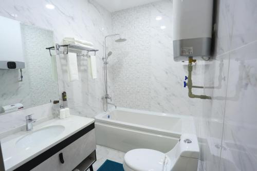 杜尚别Hotel 777的白色的浴室设有卫生间和水槽。