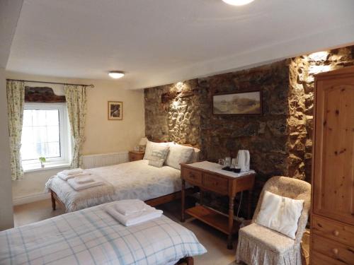 多尔盖罗Aber Cottage B&B的一间卧室配有两张床和一张桌子及椅子