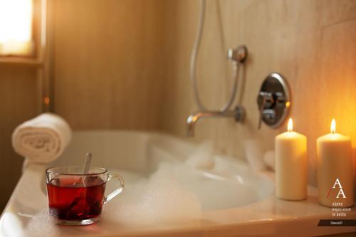 奥斯塔Alp Apartments - Stevenin11的浴室水槽上放着一杯茶和两根蜡烛