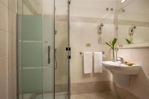 罗马多瑞卡酒店的一间带玻璃淋浴和水槽的浴室