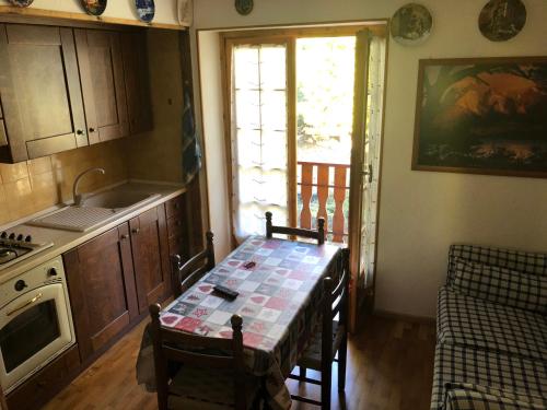 萨奥兹-杜尔克斯APPARTAMENTO MONTAGNA SAUZE D OULX的厨房配有桌子、水槽和炉灶。
