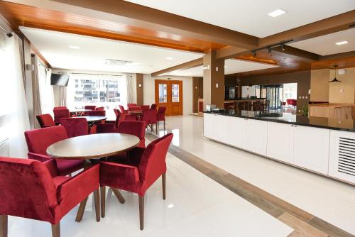 新彼得罗波利斯Hotel Alles Berg的一间用餐室,配有红色的椅子和桌子