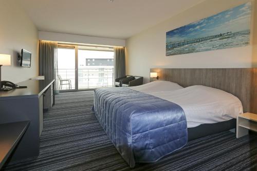奥斯坦德奥斯坦德瓦亚木多酒店的酒店客房设有一张大床和一个阳台。