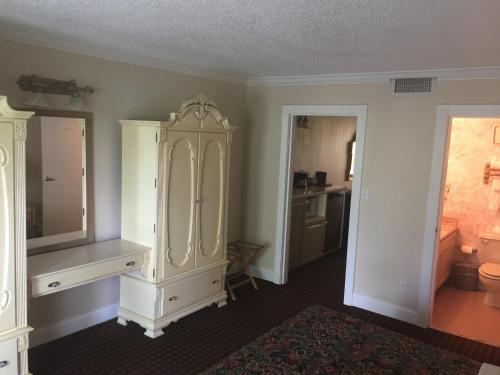 彭布罗克派恩斯大棕榈树Spa高尔夫度假酒店的客房设有大型白色橱柜和浴室。