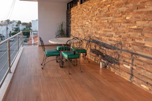 马萨特兰Apartamentos Torre II Condominios - Pet Friendly的阳台配有桌椅和砖墙