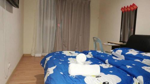 新山Polo Park Resort Condominium的一间卧室配有两张床,铺有蓝色床单,上面有牛