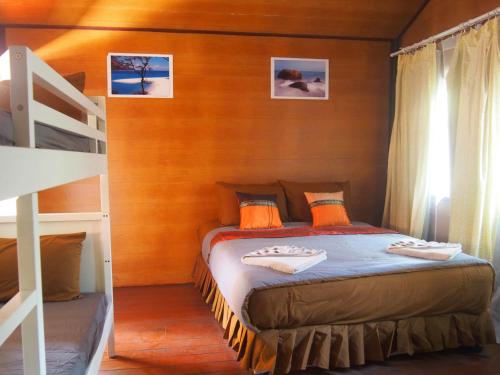 丽贝岛可可海滩小屋的一间卧室配有一张双层床和梯子