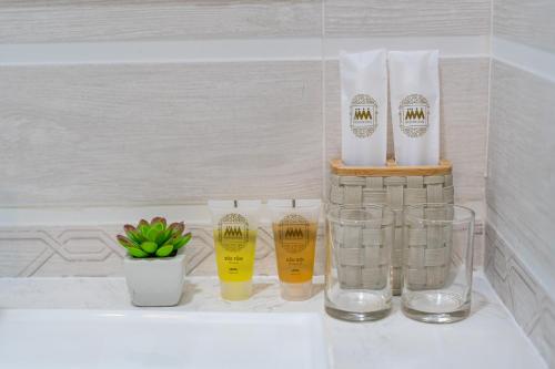 胡志明市ViVo 416 Apartment的一个带玻璃和瓶子的浴室台面,以及植物