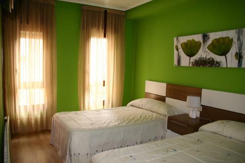 Anguiano法尔达纹纳多斯酒店及餐厅的绿色卧室设有两张床和两个窗户