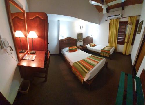 Libertador General San Martín波萨达德索尔Spa酒店的酒店客房带两张床、一张书桌和一间卧室