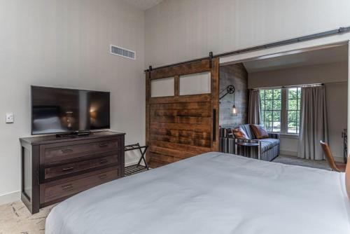 纽霍普Ghost Light Inn的一间卧室配有一张床和一台平面电视