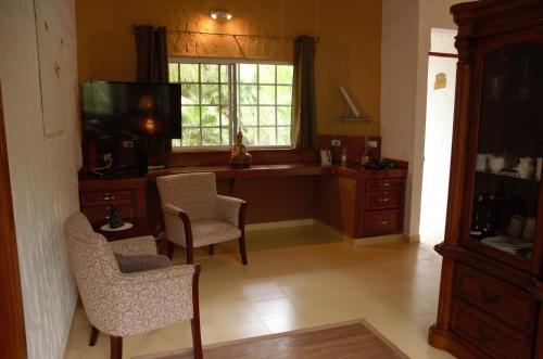 埃尔巴列德安通维拉维多利亚山林小屋的客厅配有桌椅和窗户。