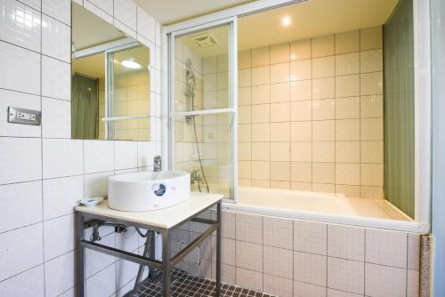 新竹豪美商旅的浴室配有盥洗盆和浴缸。